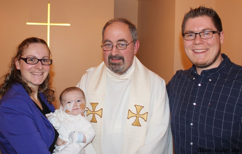 Adam fier d'être baptisé! Avec maman, papa et Father Paul.